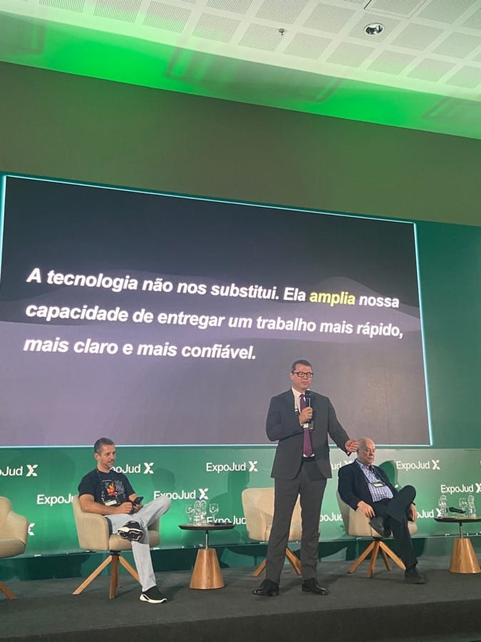 Luciano Rocha em palestra na ExpoJud com slide "A tecnologia não nos substitui — ela amplia nossa capacidade"